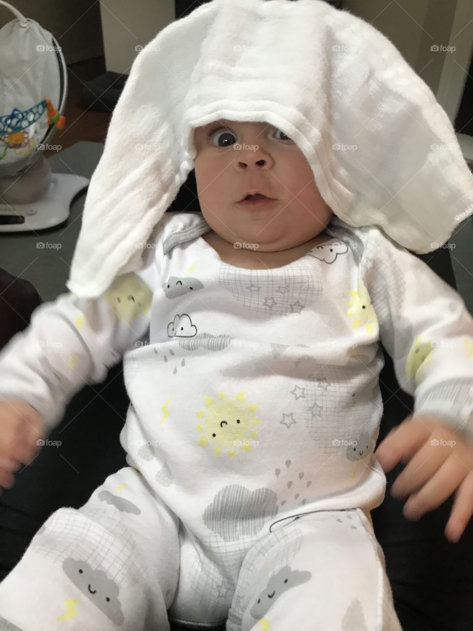 Surprised!! Wow, what's happening. Cute baby reacting to diaper placed on his head. 
