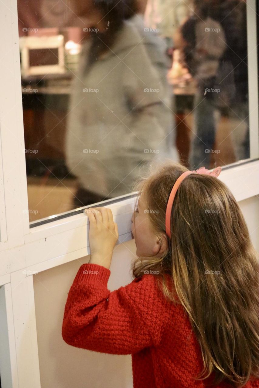 A girl looking and hide in window 
