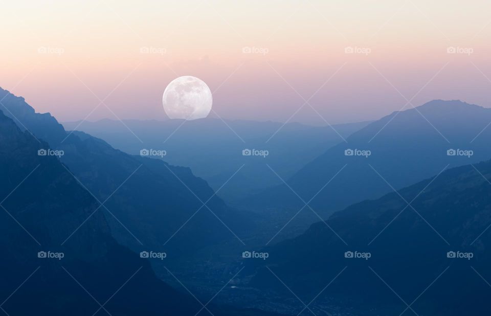 Moon appearing at the end of valley just after sunset.