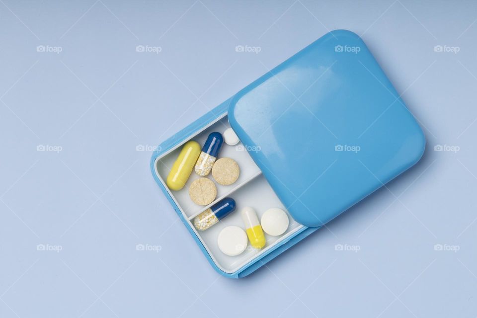 Pillbox on blue background.  medicine concept