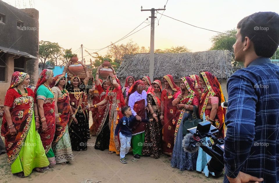 A ritual called 'Chak Bhaat' in marraiges in Rajasthan, India. All female dresses and take 2 earthen pots to Well -pray to God, water, earth and come back home both pot filled. Along with DJ Band music, dance and photographer capture all the moments.