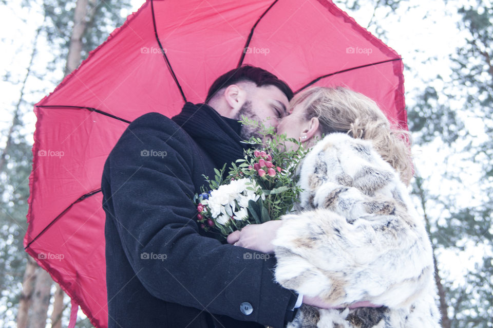 lovers kissing under an umbrella