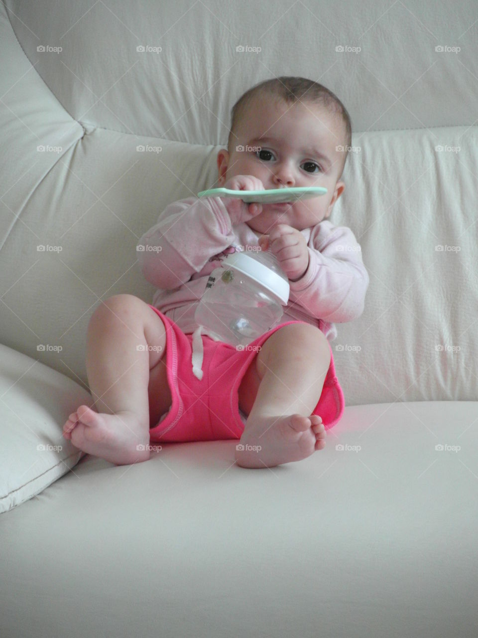 Sahar-Marie and baby bottle. cute baby girl on couch with baby bottle