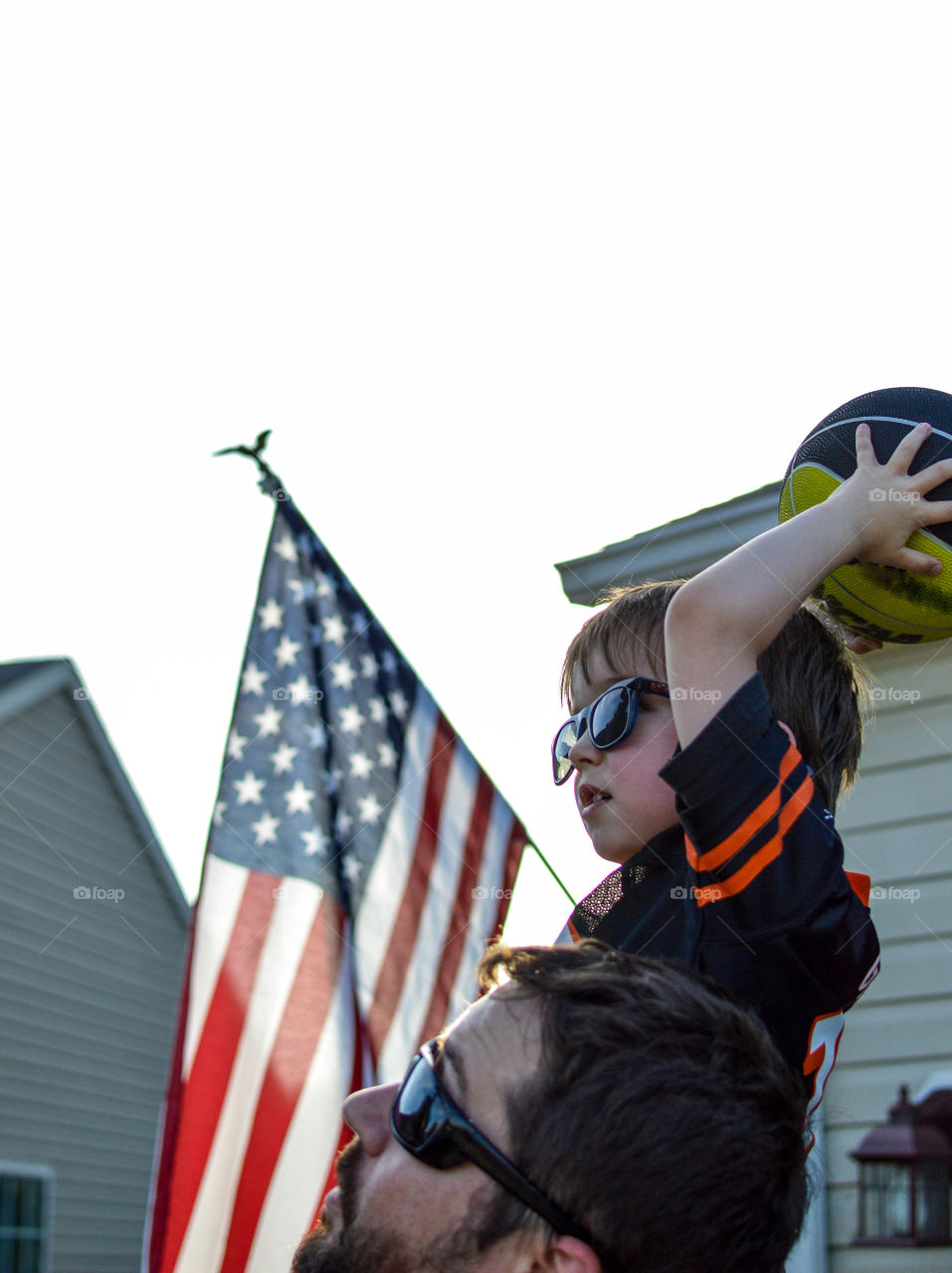 Cute boy with ball on father shoulder