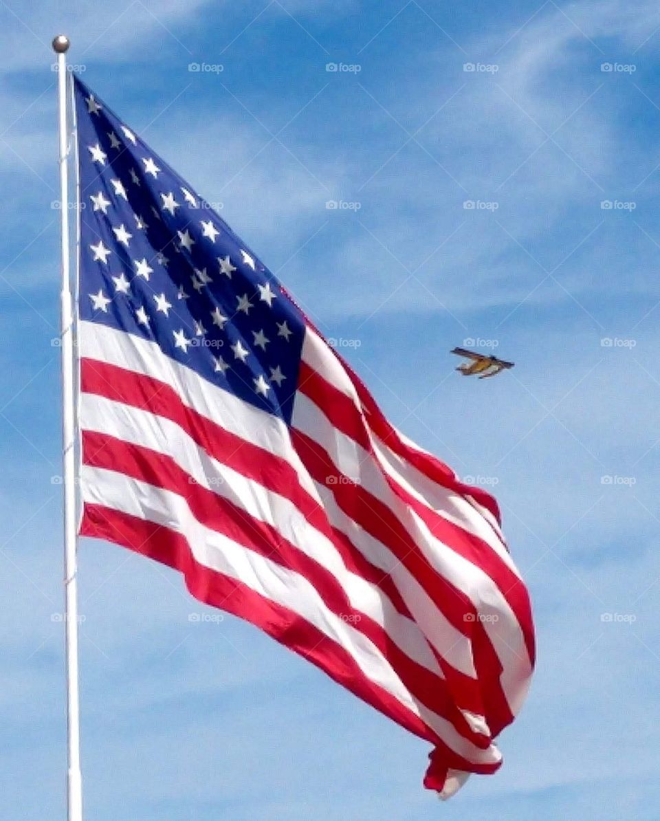 American flag with plane in sky