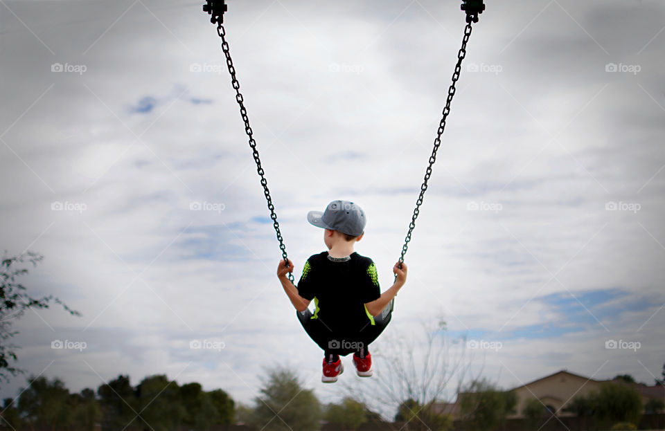 Rear view of boy swinging on swing