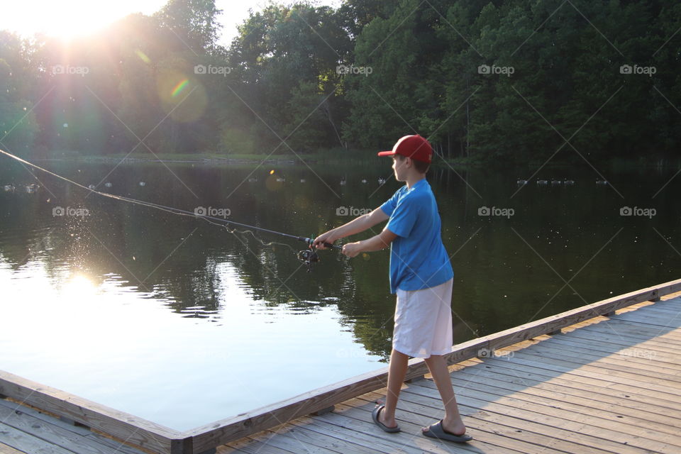 Boy fishing with sun shining upon him