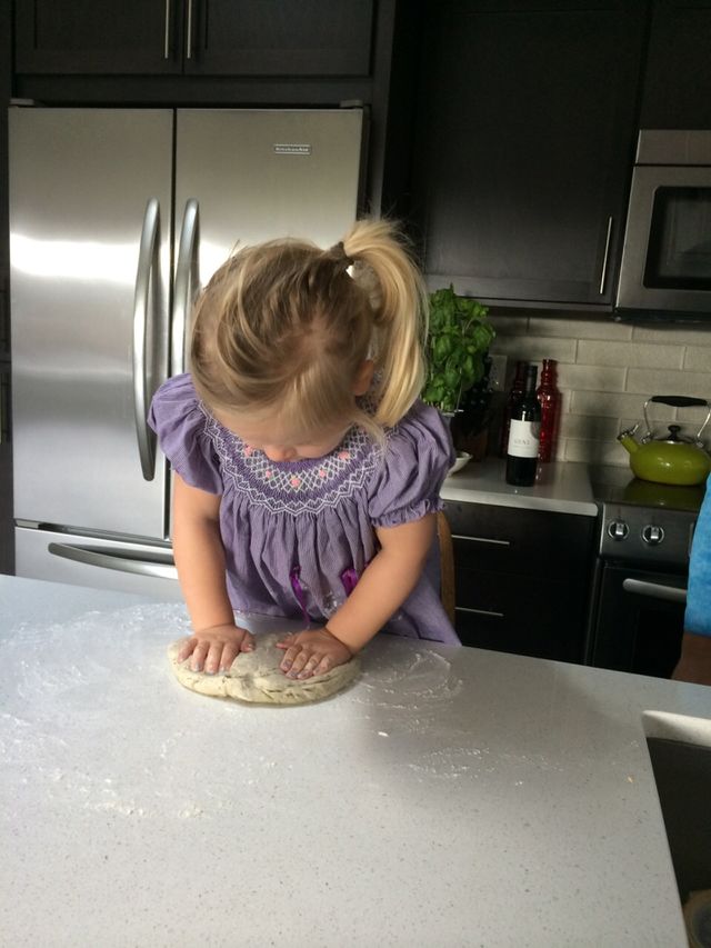 Little girl in purple dress baking