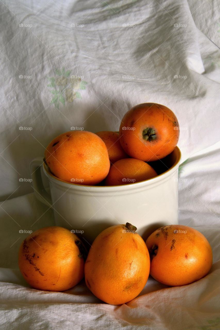 Close-up of loquat fruits on mug