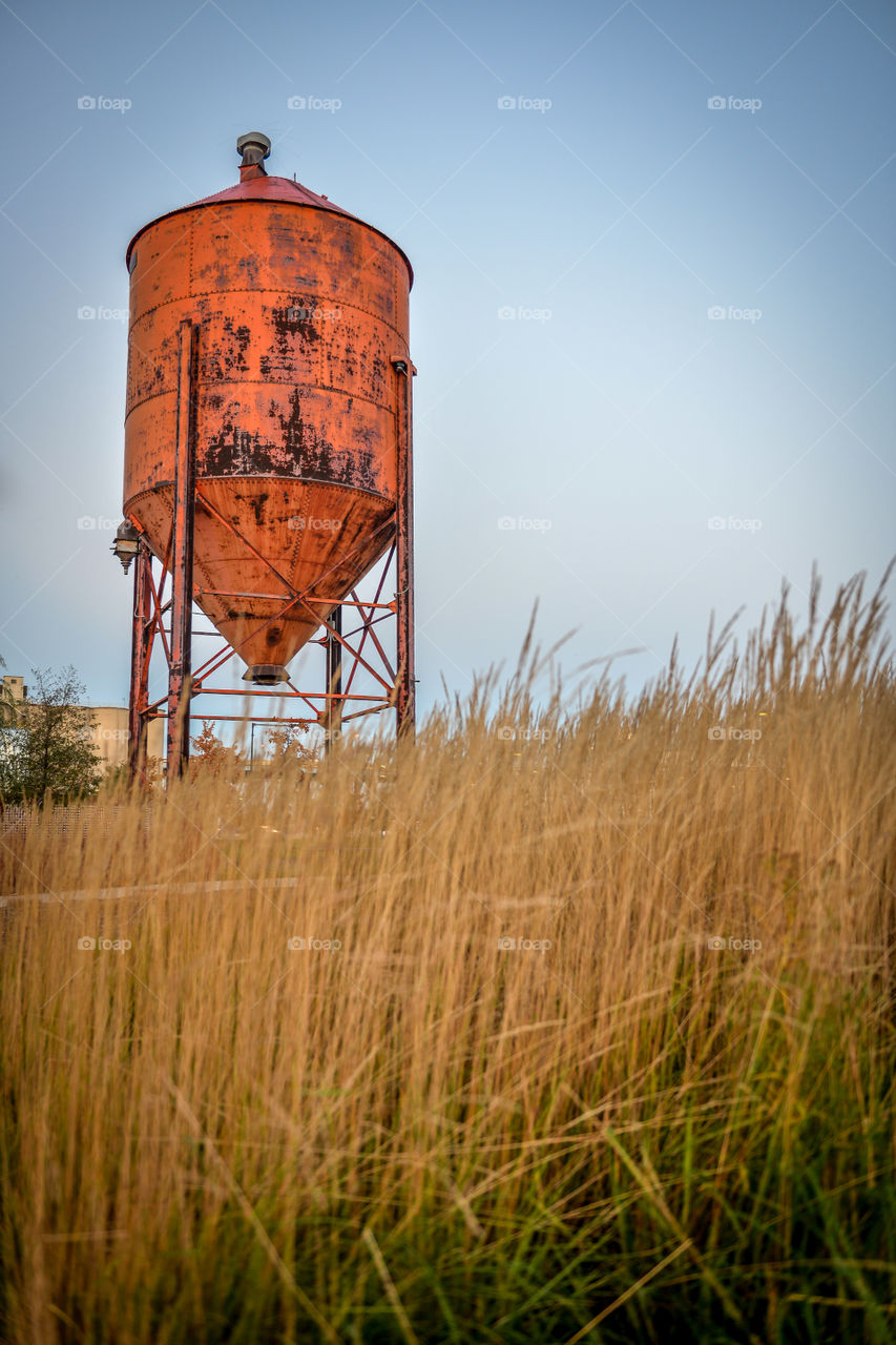 Orange farm equipment in field. Orange hopper in farm field in Wisconsin. 