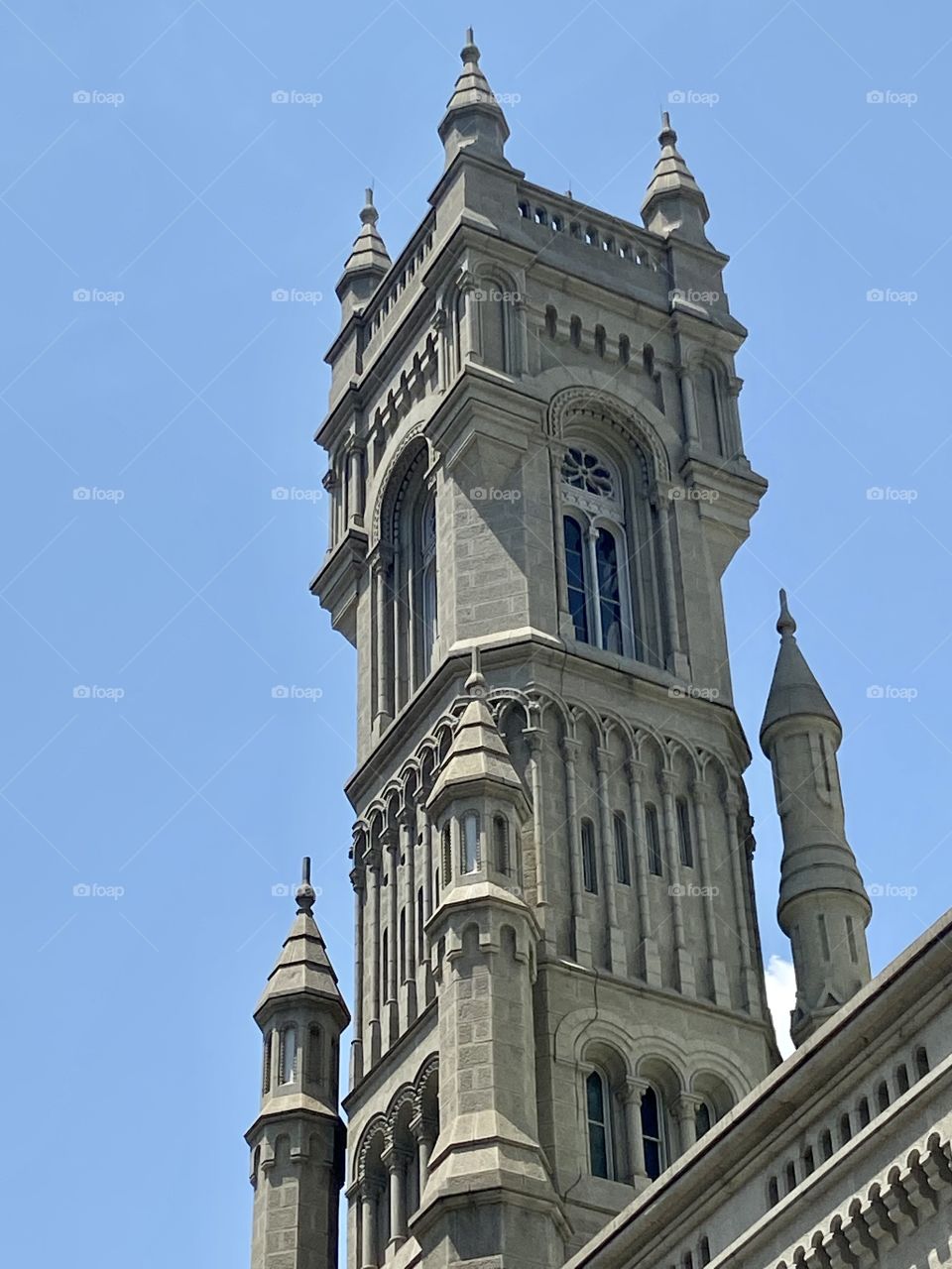 The top of a very ornate concrete historical building against a blue sky