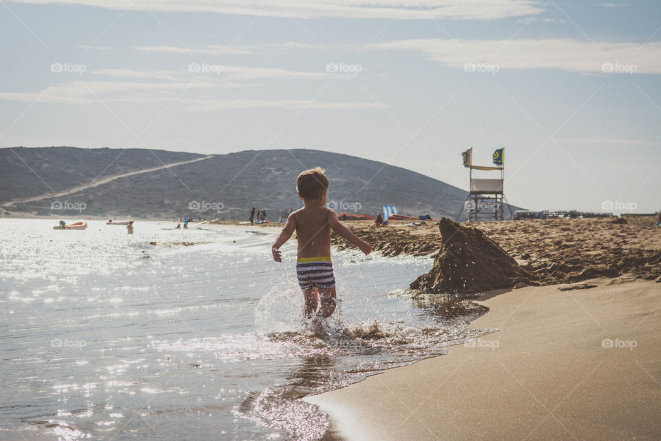 A boy is playing on a beach