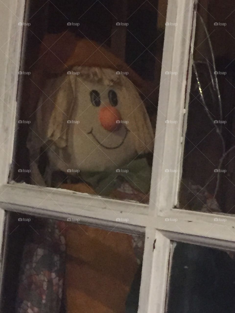 Eerie Scarecrow behind white door frame 
