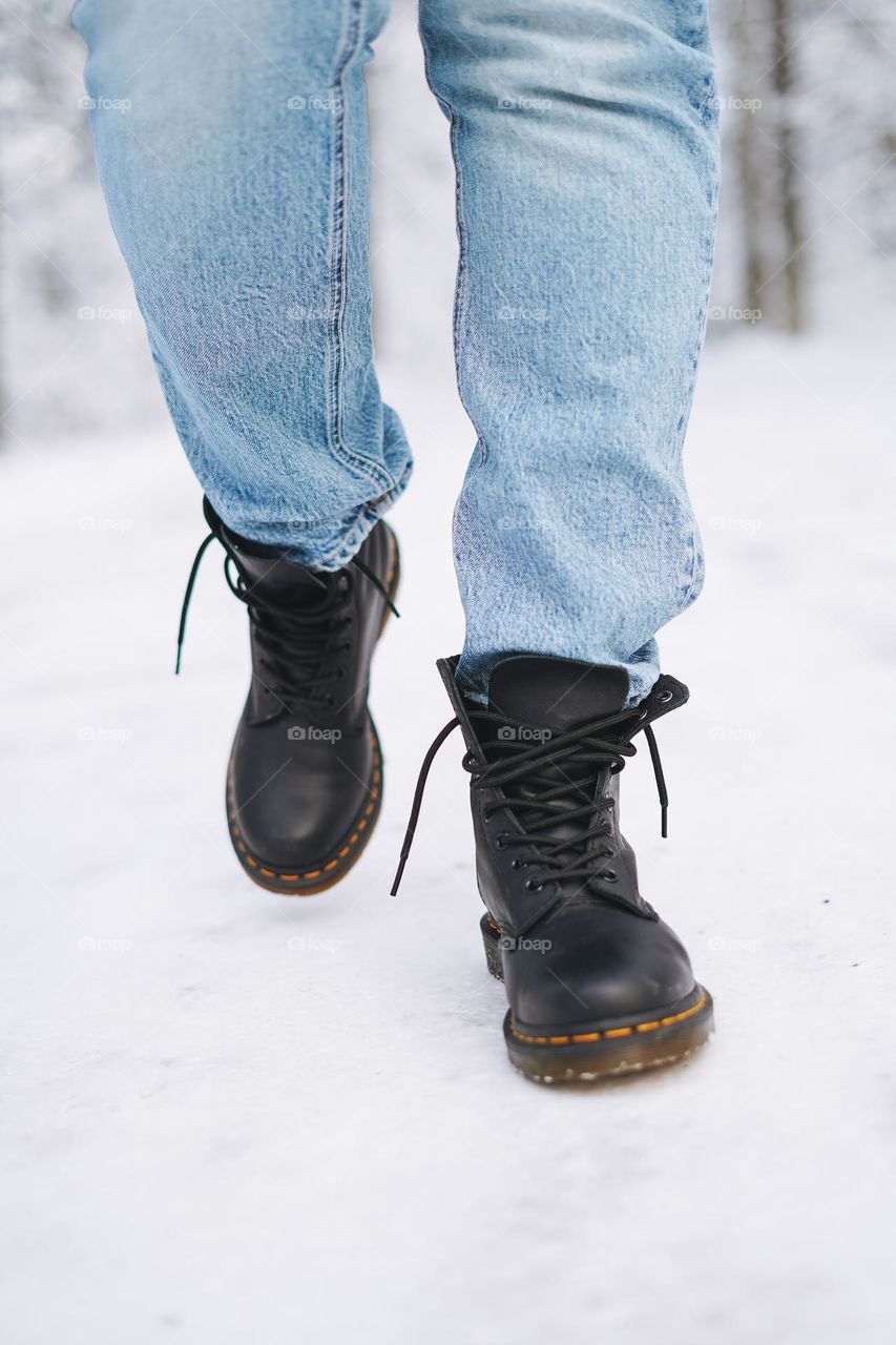 Young woman in black Dr. Martens boots in winter forest
