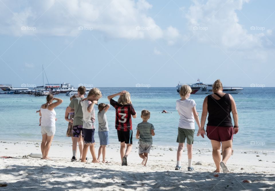 Big family enjoy their summer on the beautiful beach together