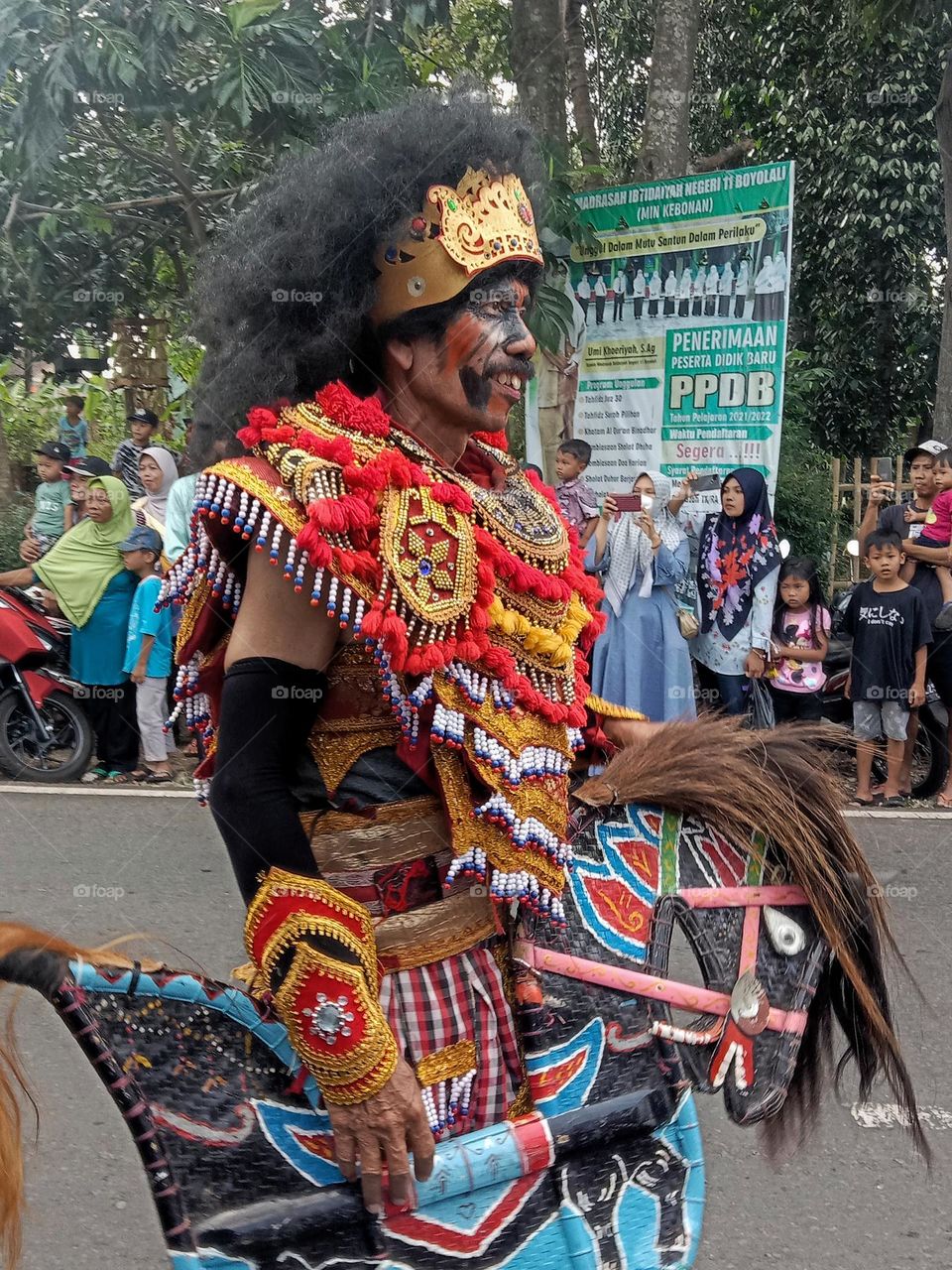 A man is performing a reog dance to enliven a carnival event to celebrate Indonesia's independence day.