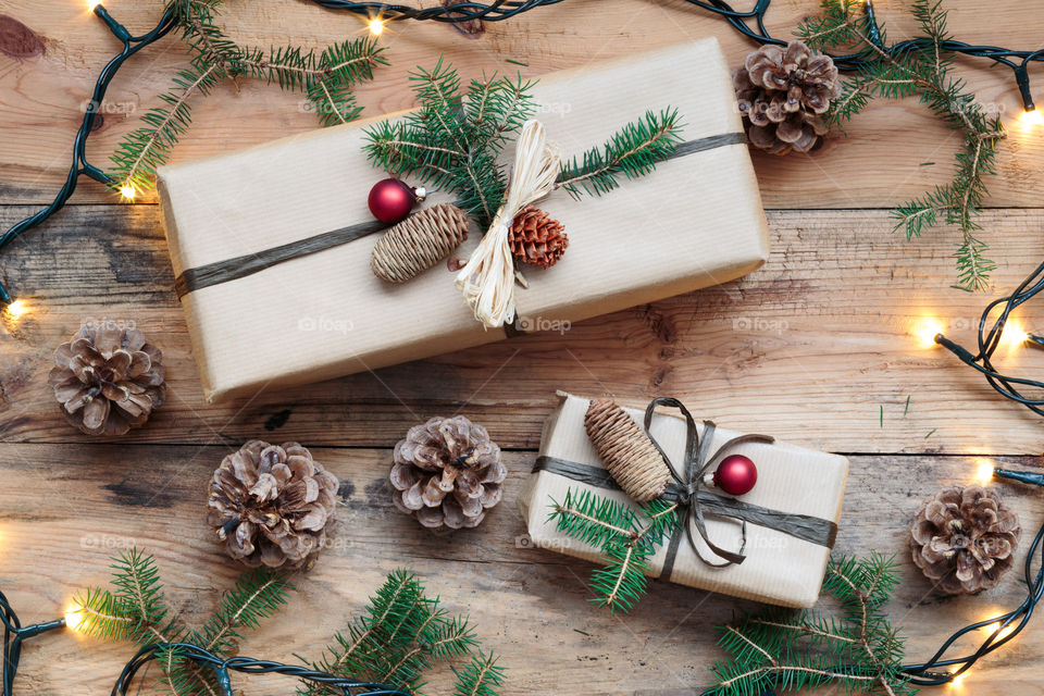 Pine cone with gift on wooden table