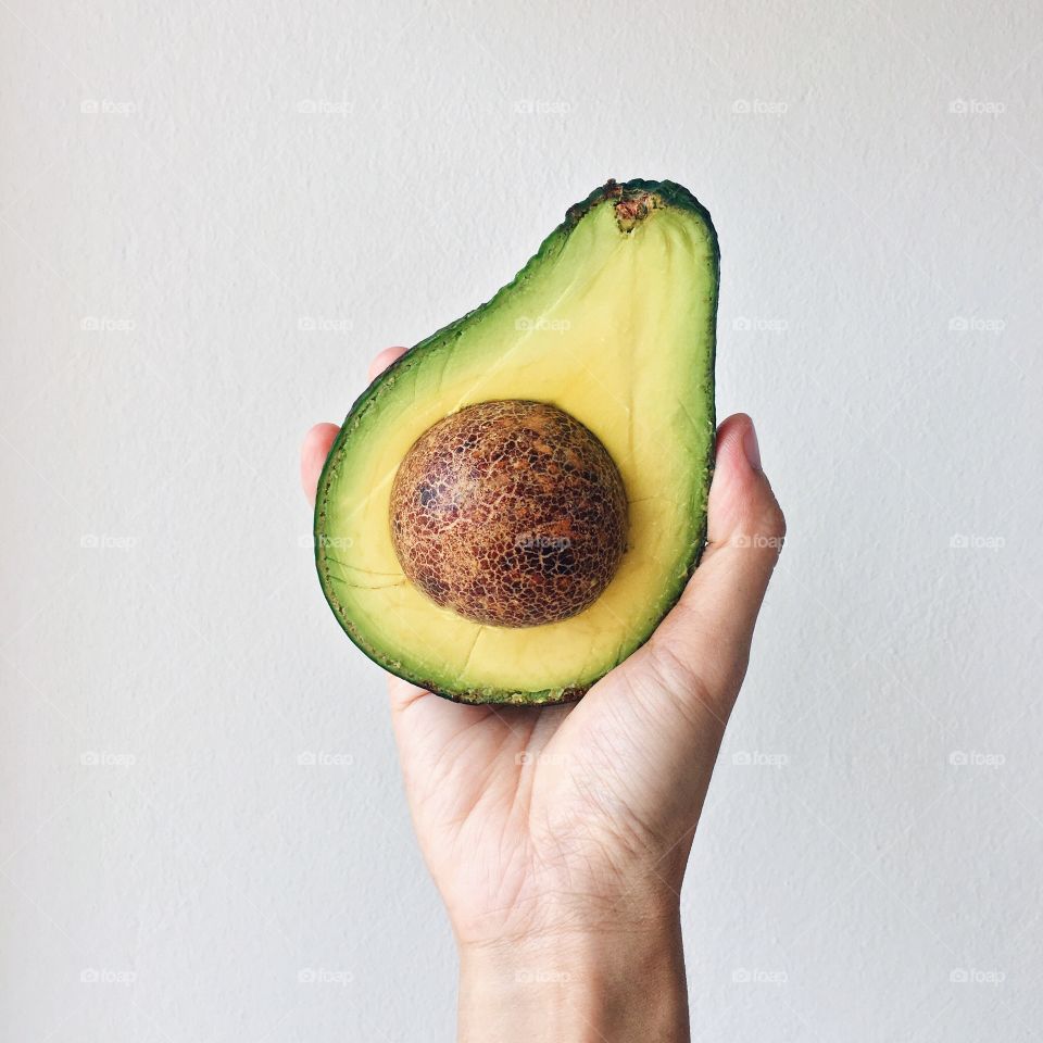 Studio shot of avocado in human hand