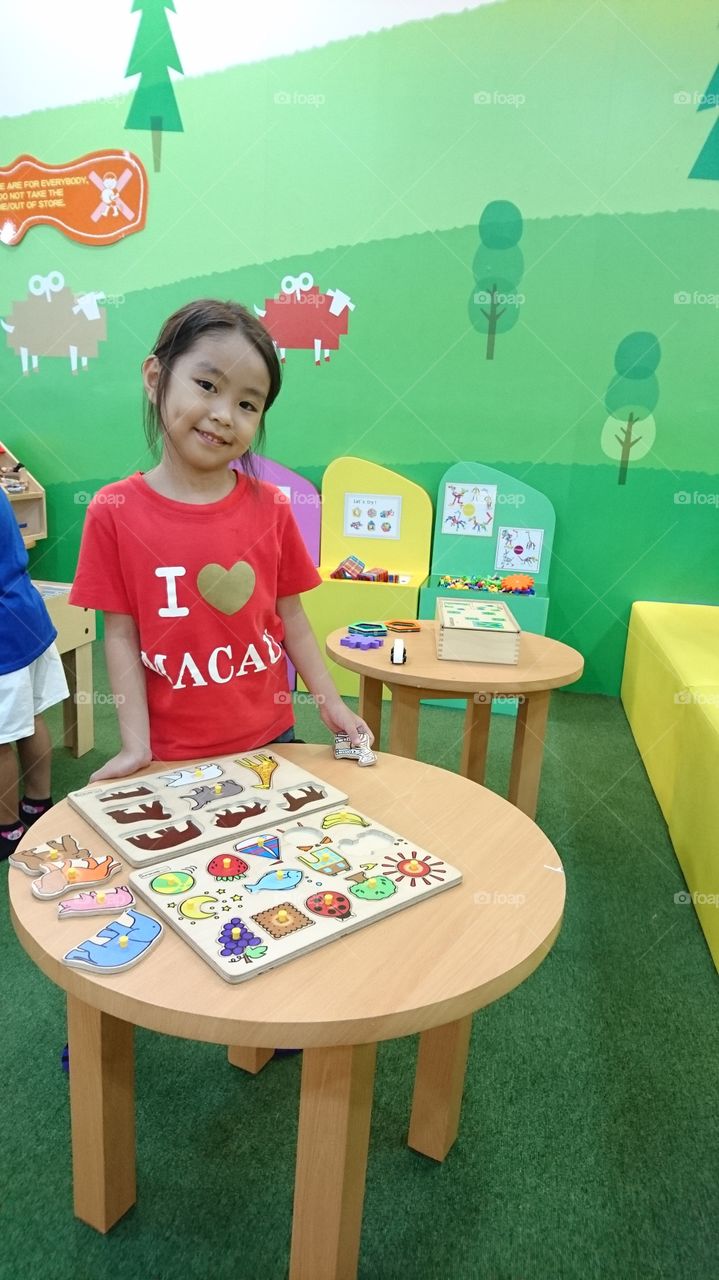 my youngest daughter  Sol, smiles after completing her puzzle game in a kidszona SM Masinag Antipolo,,