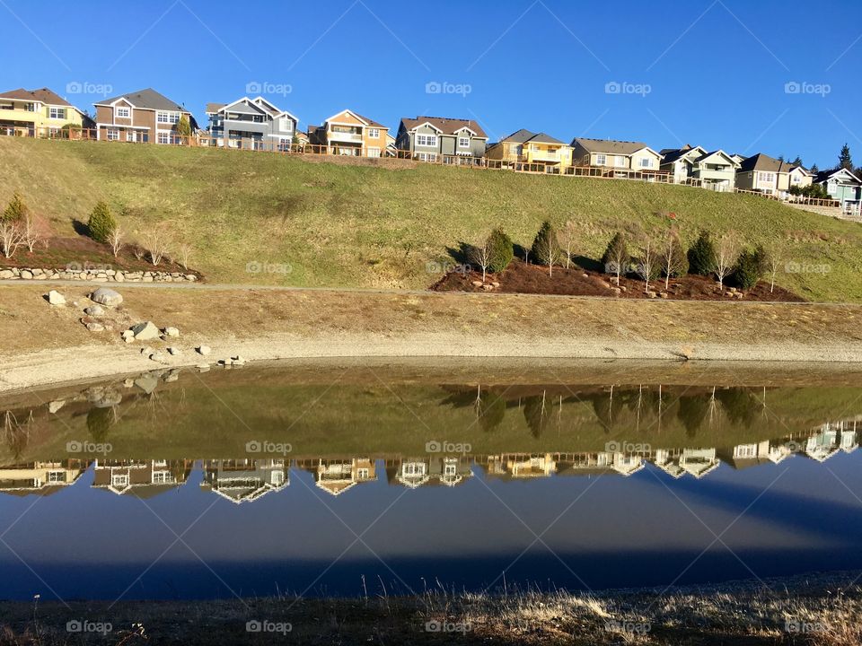 Houses with reflection in retention pond. 