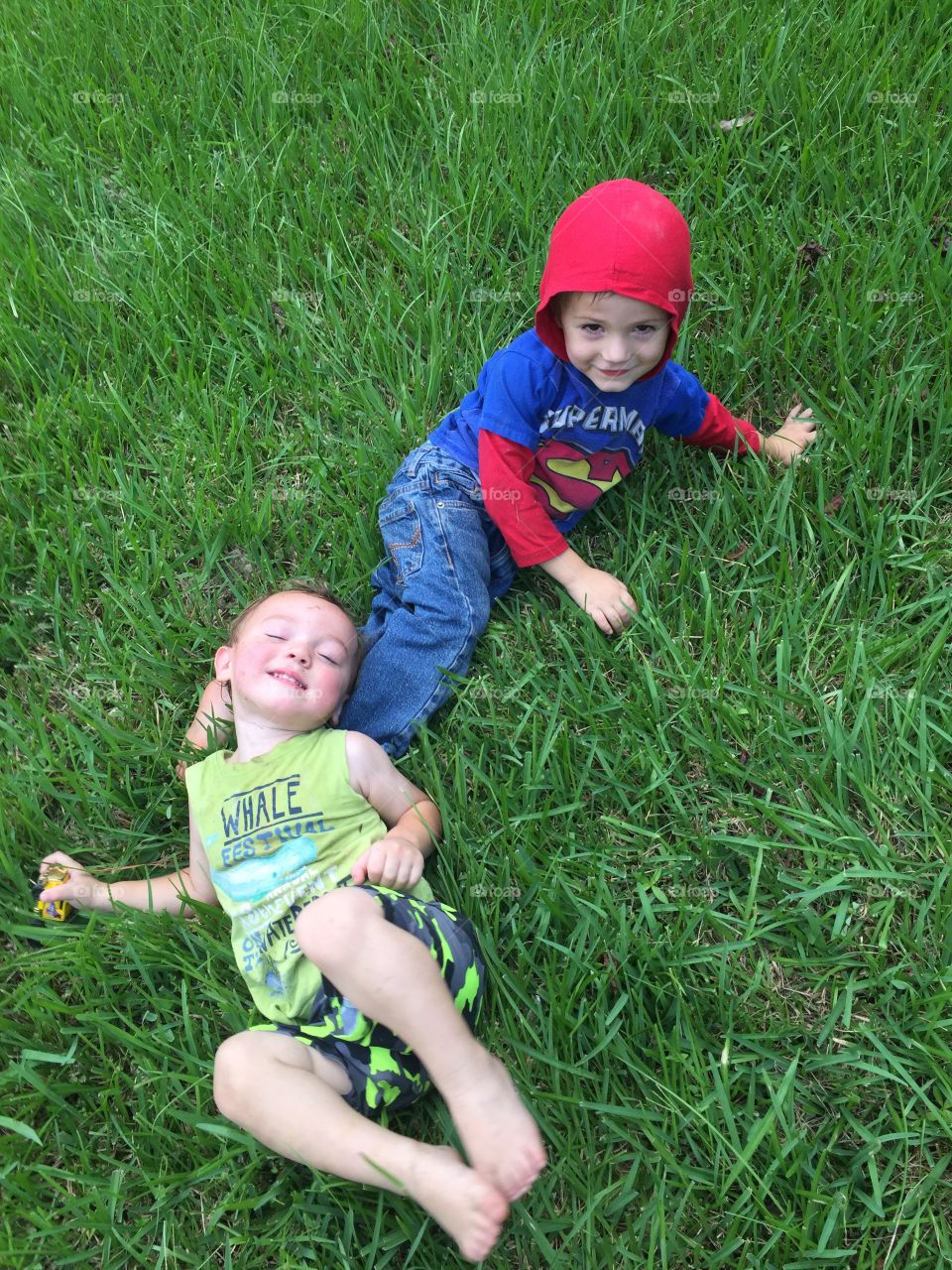 Boys playing in the grass in front yard having fun