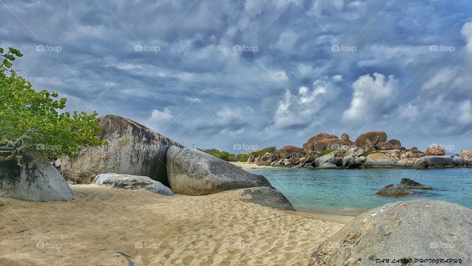 Boulders on sandy beach at coastline
