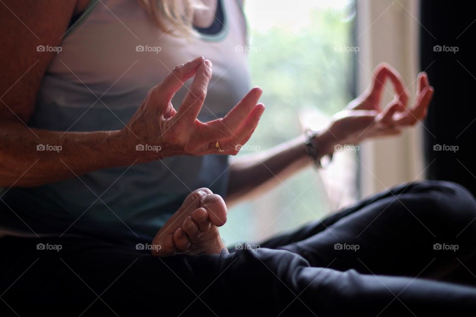 Close-up of the hands of a woman meditating in the lotus position