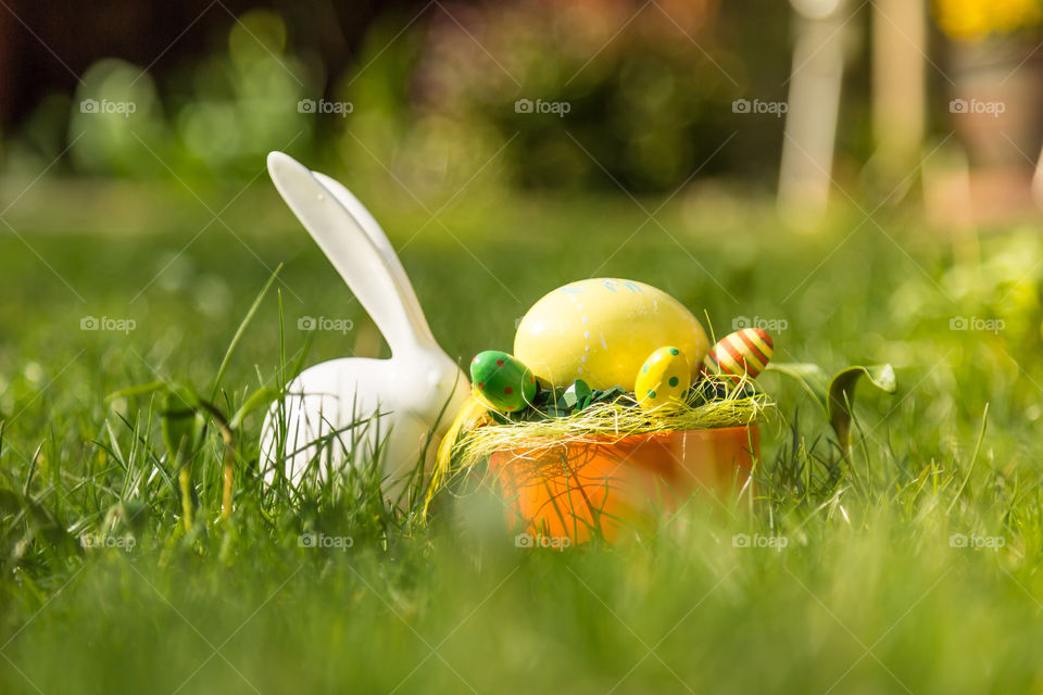 Easter decoration in garden. Easter decoration with busy and eggs on grass in garden.