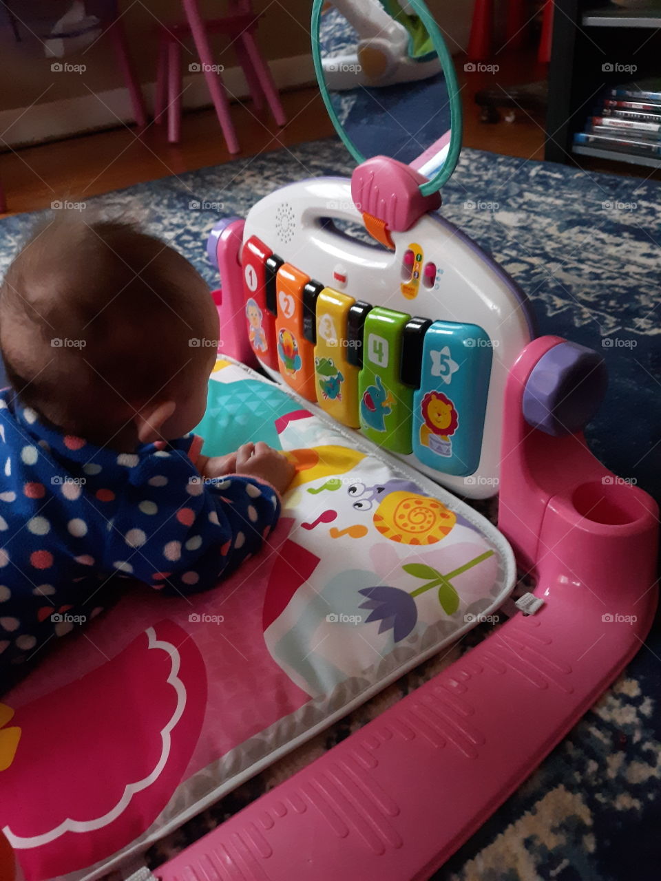Baby having tummy time with floor mat piano mobile toy
