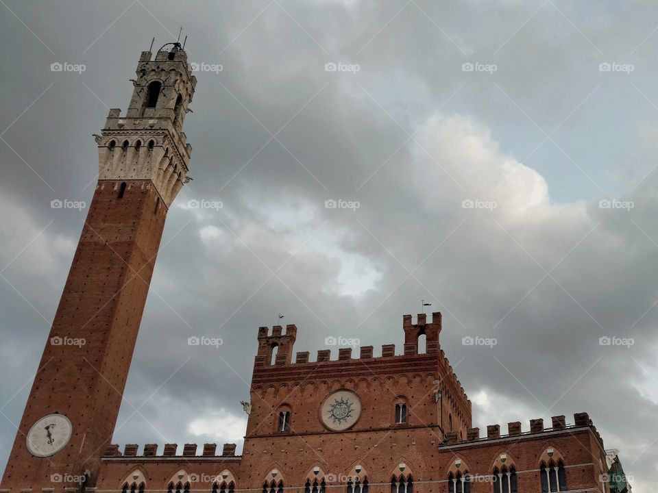 The Palazzo Pubblico of Siena, Italy at twilight on a cloudy day