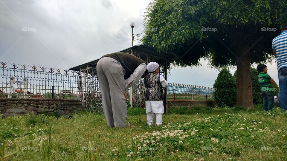 a man and his son offering prayers