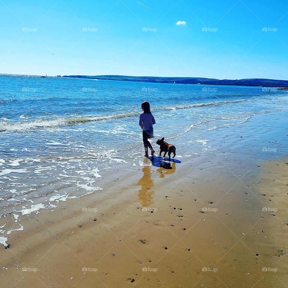 Child and her dog on the beach