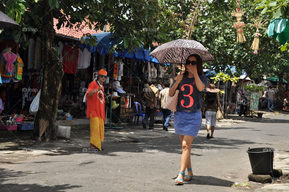 Woman holding umbrella walking on street