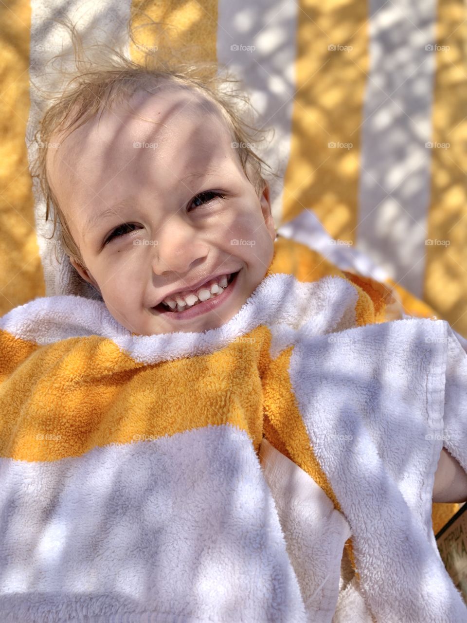 Baby boy at beach in yellow towel 