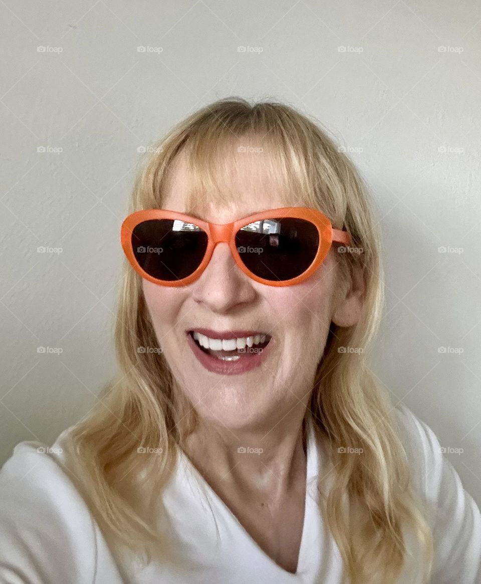 Woman laughing wearing orange sunglasses 