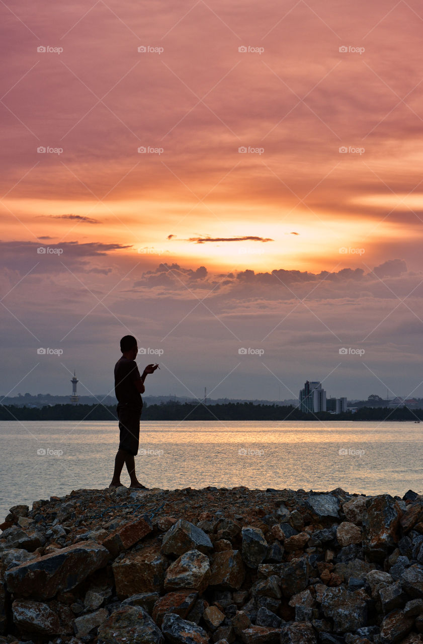 Silhouette of a person standing on rocks
