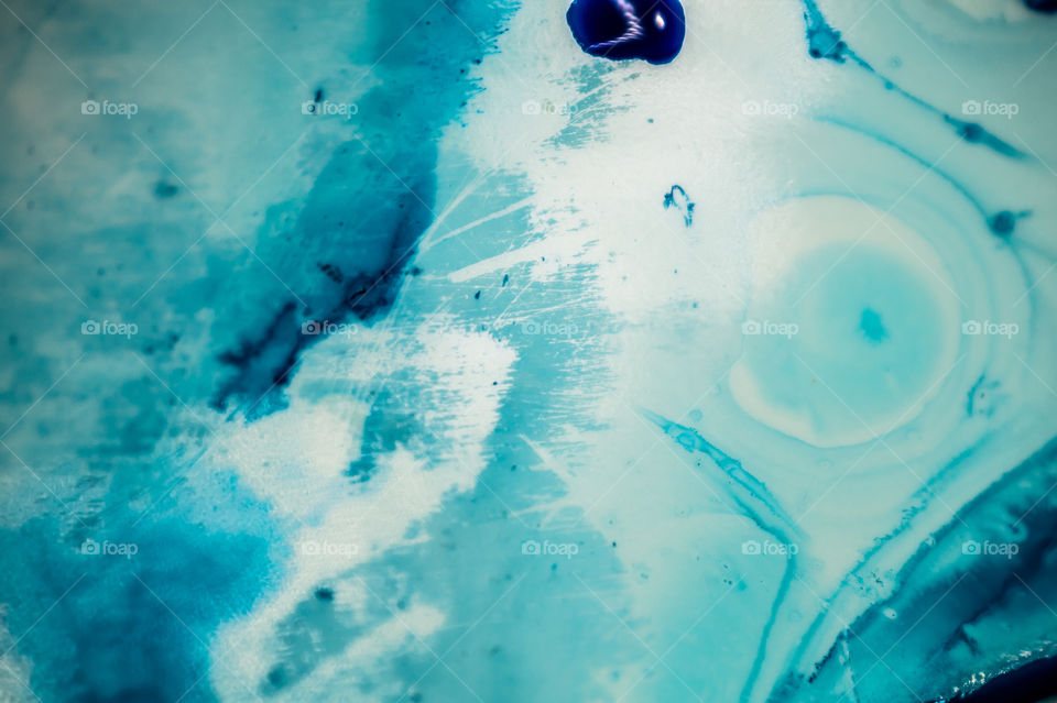 The ink to refill the printer cartridge was spilled onto the white washbasin and the paints blended into abstract drips and patterns.