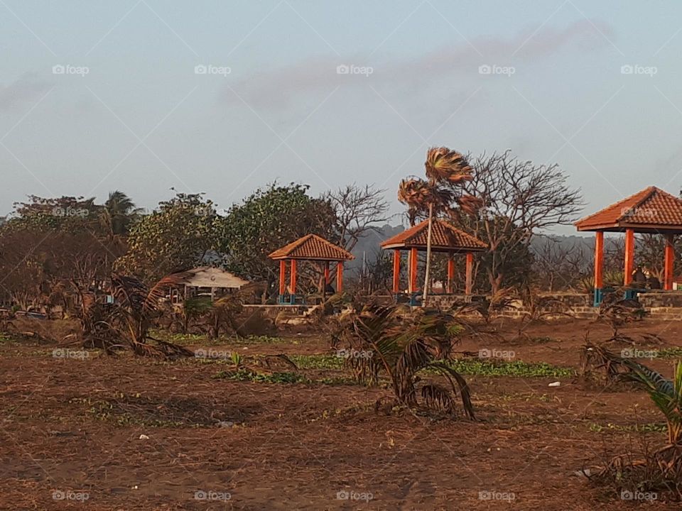 a resting place building located on the coast of Cilacap, Indonesia surrounded by palm trees