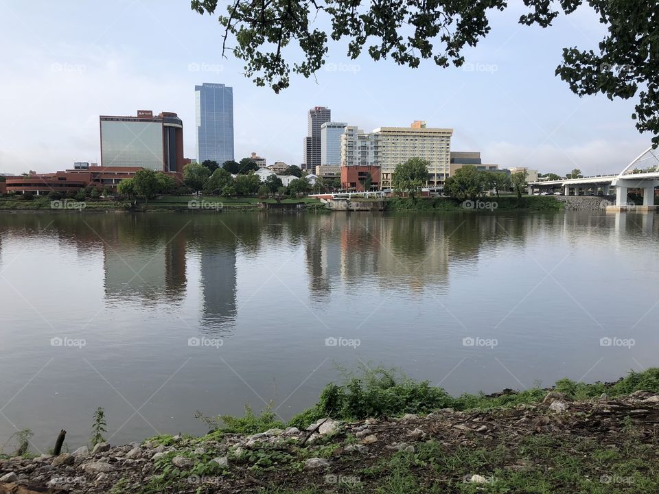 The beautiful Little Rock Skyline along a calm Arkansas River as viewed from the North Shore 