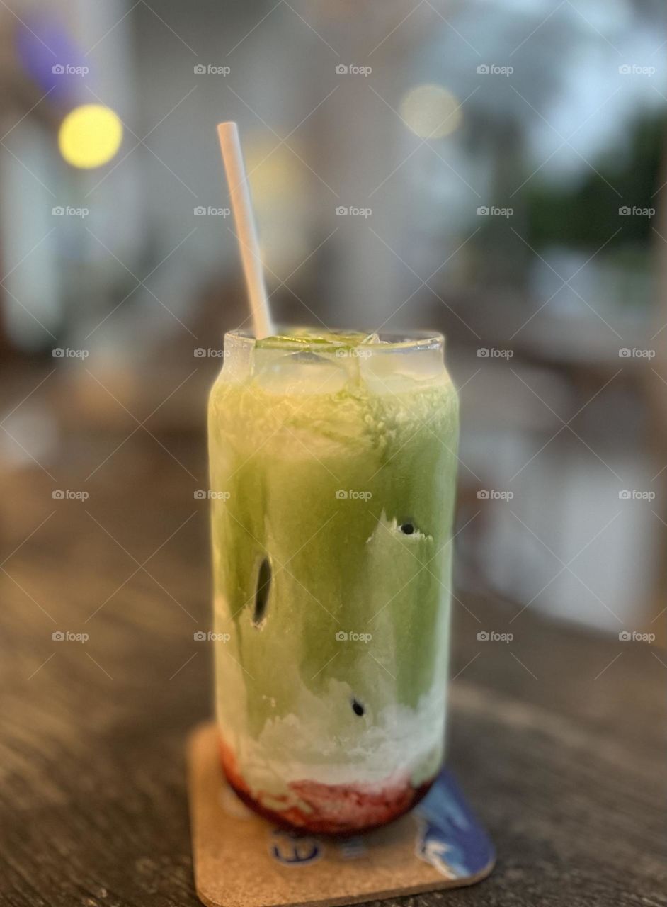 A glass of cold drink with matcha and strawberry 