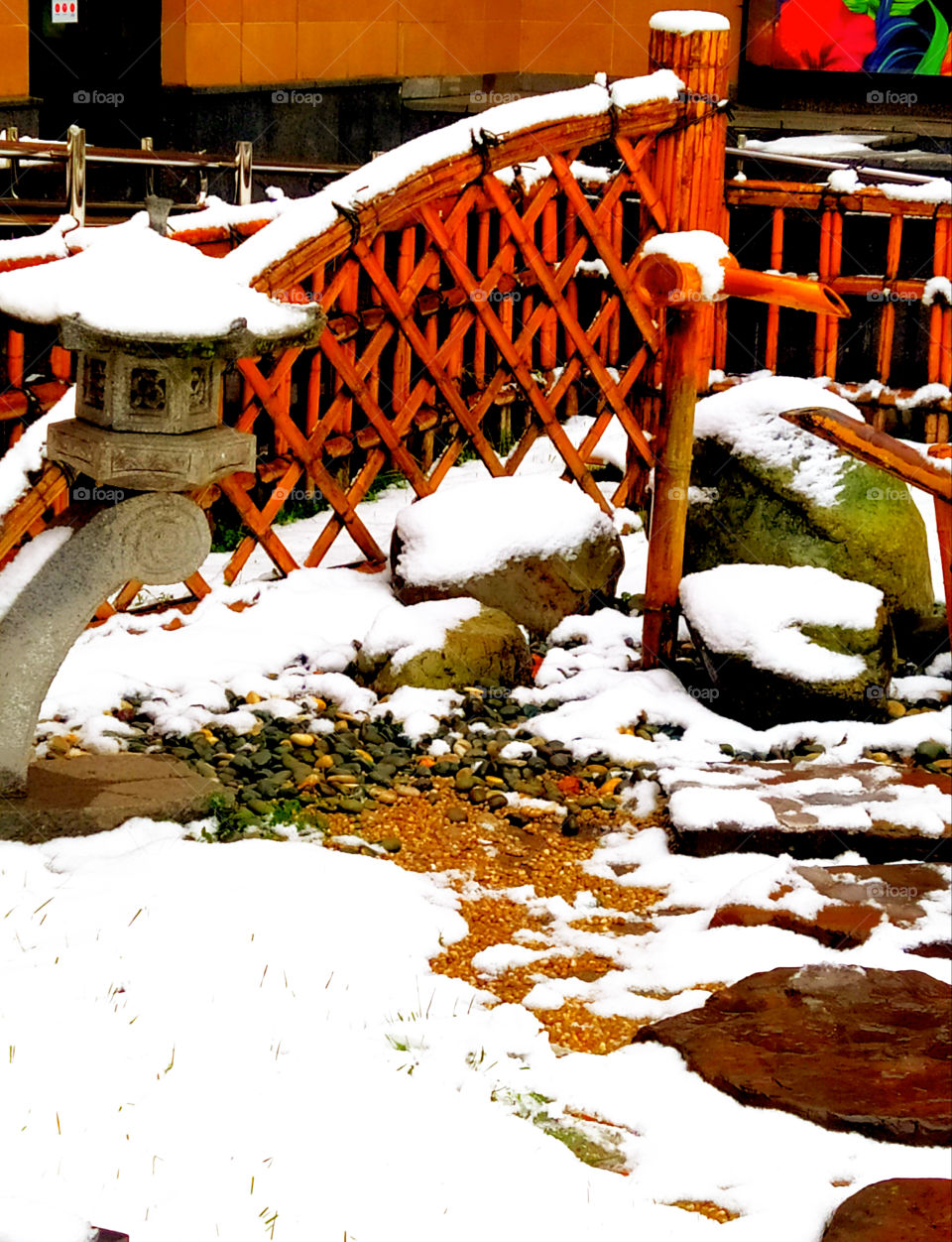 Stone house, wooden fence in the snow