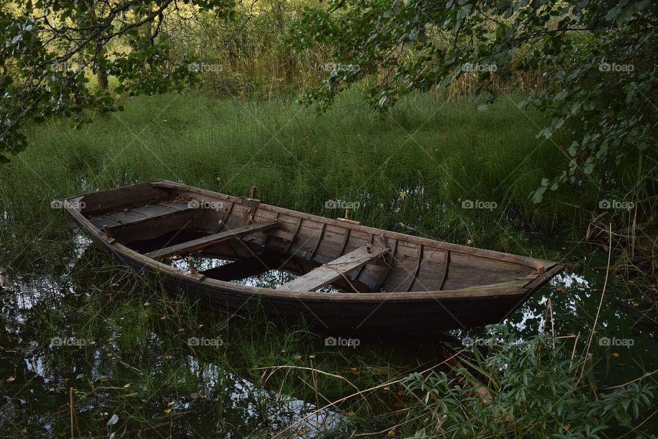 Wooden abandoned boat on the lake