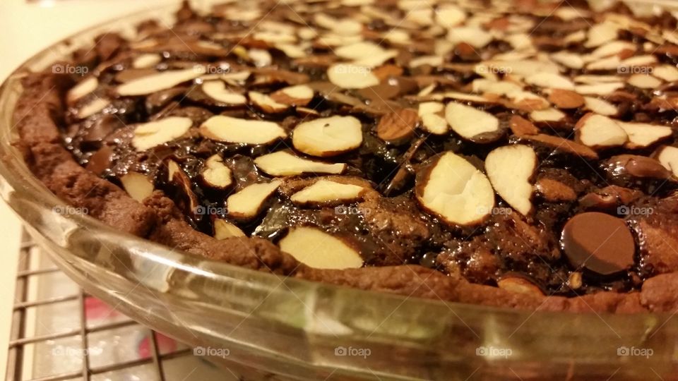 fudge brownie pie with a chocolate pie crust. Drizzled with dark chocolate syrup and sprinkled with slivered almonds.