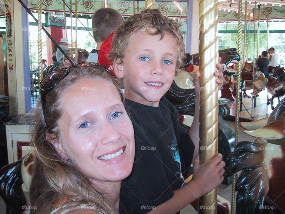 Mother and Son on carousel .