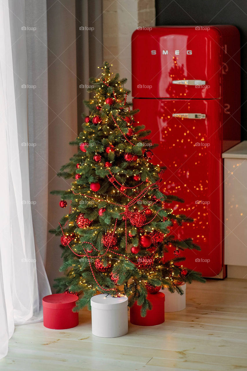 Festive winter cozy kitchen interior with garlands, decorations and gifts.  Christmas dinner at the decorated table.