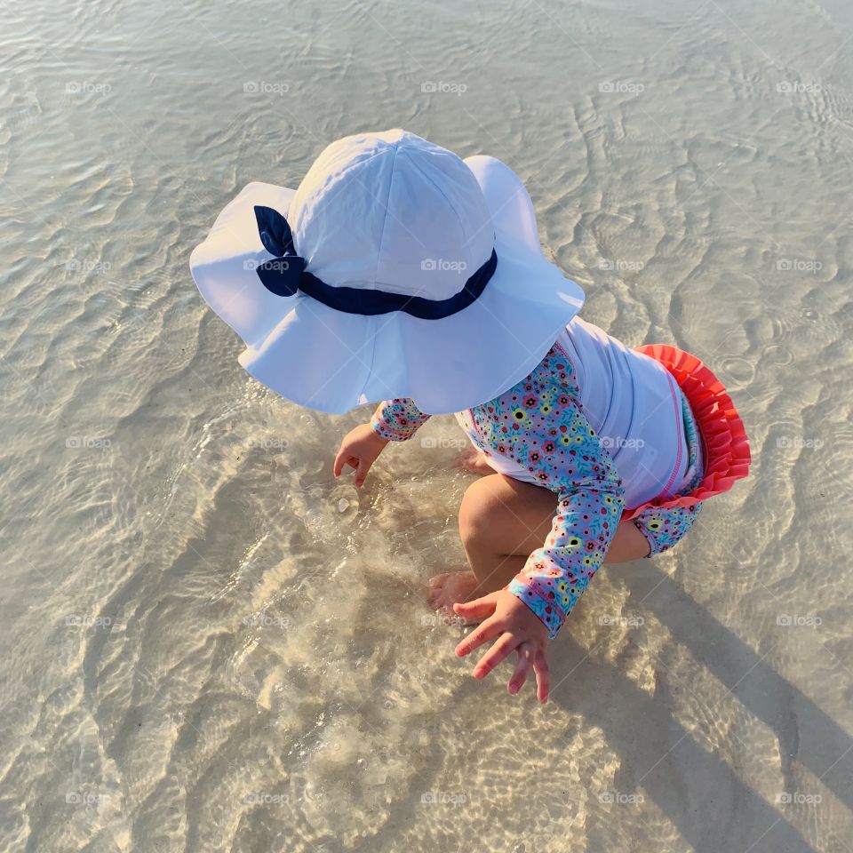 Baby at the Beach Looking for Shells