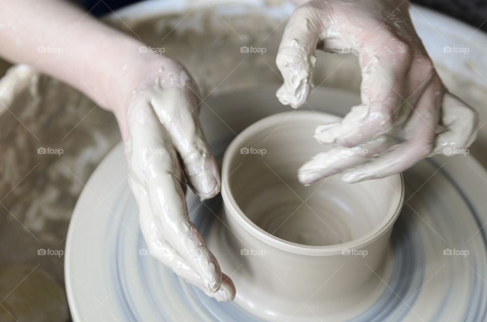 Potter's hands working over potter's wheel