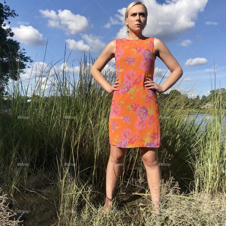 Tall grass and a clear blue sky at the beach. Modeling a floral dress while barefoot. 