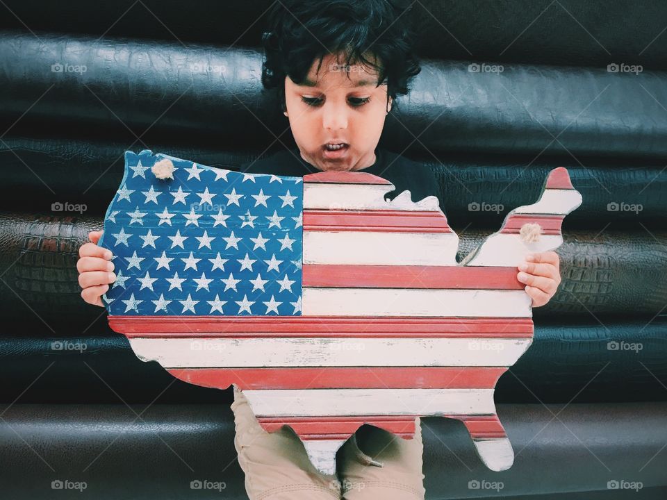 Kid holding American map and flag 