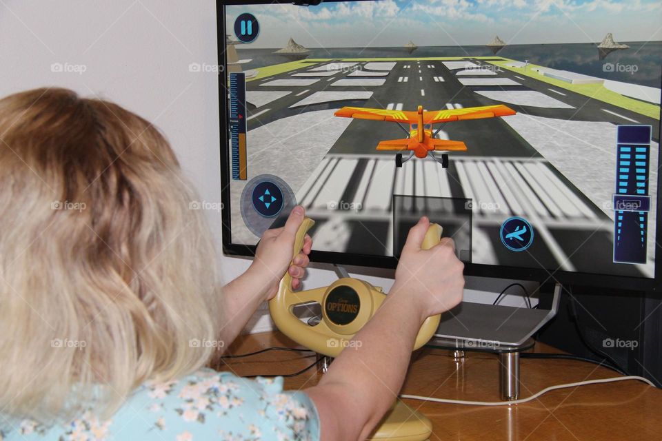 Pilot in training playing with video flight simulator using flight yoke